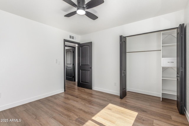 8602 N 42nd Dr, Phoenix, AZ 85051 - unfurnished bedroom featuring wood finished floors, a ceiling fan, and a closet