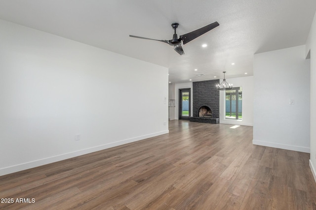 8602 N 42nd Dr, Phoenix, AZ 85051 - unfurnished living room featuring wood finished floors, a ceiling fan, a chandelier, a brick fireplace, and recessed lighting