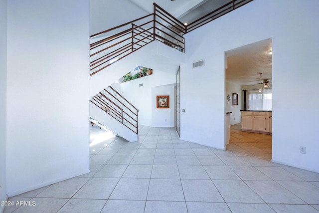 interior space with a high ceiling, ceiling fan, and tile patterned floors