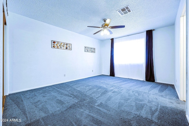 unfurnished room with ceiling fan, a textured ceiling, and dark colored carpet