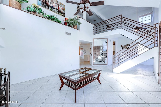 living room featuring light tile patterned floors, a high ceiling, and ceiling fan