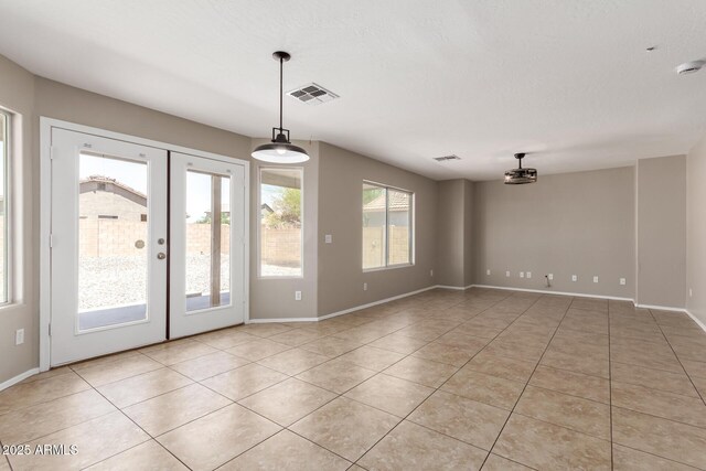 906 S 242nd Dr, Buckeye, AZ 85326 - empty room with light tile patterned floors, french doors, and baseboards