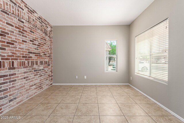 906 S 242nd Dr, Buckeye, AZ 85326 - spare room featuring brick wall and light tile patterned floors