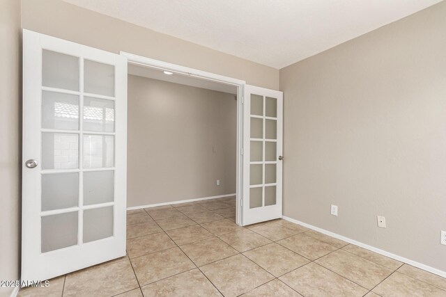 906 S 242nd Dr, Buckeye, AZ 85326 - unfurnished room featuring french doors, light tile patterned floors, and baseboards