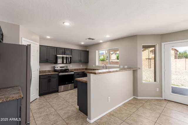 906 S 242nd Dr, Buckeye, AZ 85326 - kitchen featuring appliances with stainless steel finishes, a peninsula, light tile patterned floors, recessed lighting, and gray cabinets