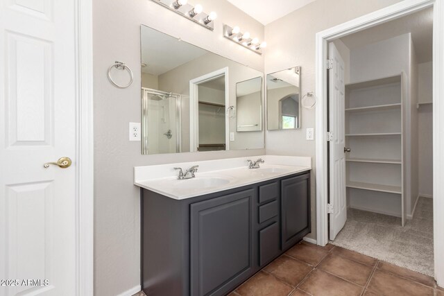 906 S 242nd Dr, Buckeye, AZ 85326 - full bath with double vanity, a shower stall, a walk in closet, tile patterned floors, and baseboards