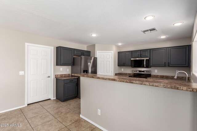 906 S 242nd Dr, Buckeye, AZ 85326 - kitchen with stainless steel appliances, a peninsula, light tile patterned flooring, recessed lighting, and baseboards