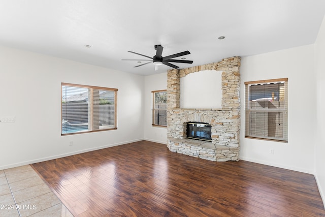 unfurnished living room with ceiling fan, a fireplace, and hardwood / wood-style flooring