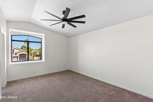 carpeted spare room featuring ceiling fan and lofted ceiling