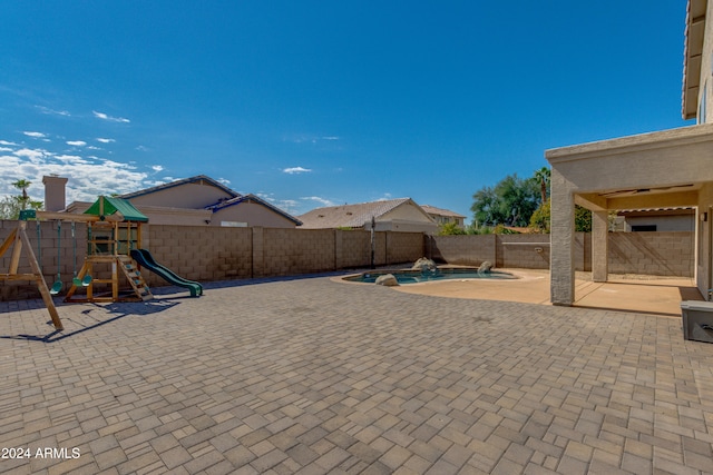 view of patio with a fenced in pool and a playground