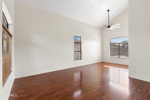 unfurnished living room with ceiling fan, high vaulted ceiling, and dark wood-type flooring