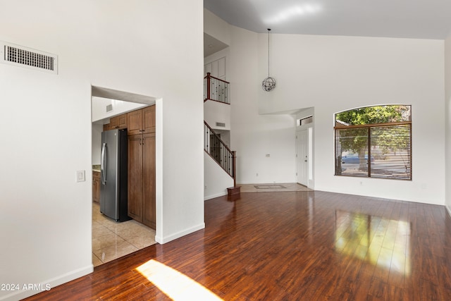 interior space with light wood-type flooring and high vaulted ceiling