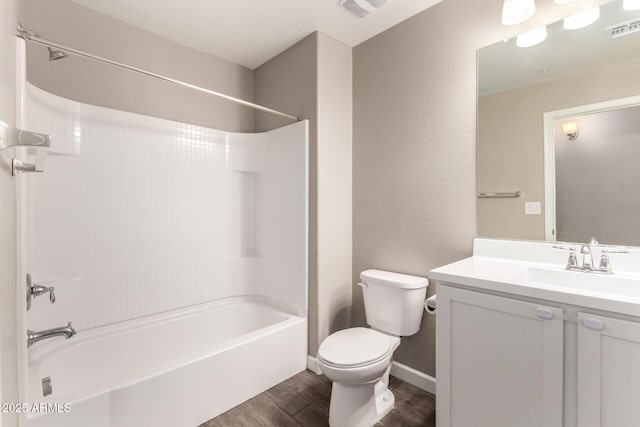 full bath featuring toilet, wood finished floors, vanity, visible vents, and washtub / shower combination