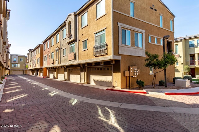 view of building exterior featuring a residential view and community garages