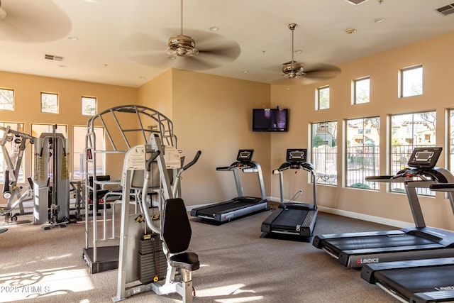 exercise room with a ceiling fan, visible vents, and baseboards