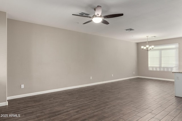 unfurnished room featuring visible vents, dark wood finished floors, baseboards, and ceiling fan with notable chandelier