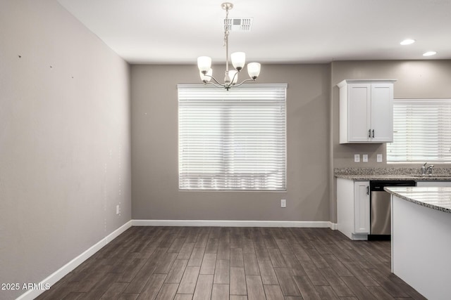 kitchen with dishwasher, dark wood finished floors, white cabinetry, and baseboards