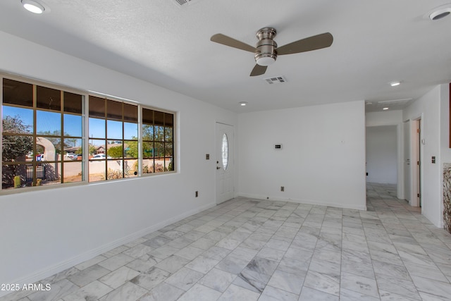 empty room featuring visible vents, marble finish floor, a ceiling fan, and baseboards