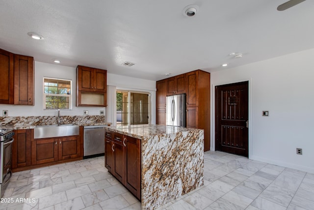 kitchen with visible vents, light stone countertops, appliances with stainless steel finishes, marble finish floor, and a sink