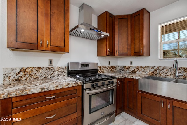 kitchen with light stone counters, a sink, stainless steel range, wall chimney exhaust hood, and marble finish floor