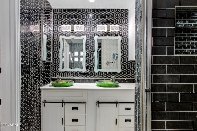 bathroom with double vanity, tile walls, and a sink