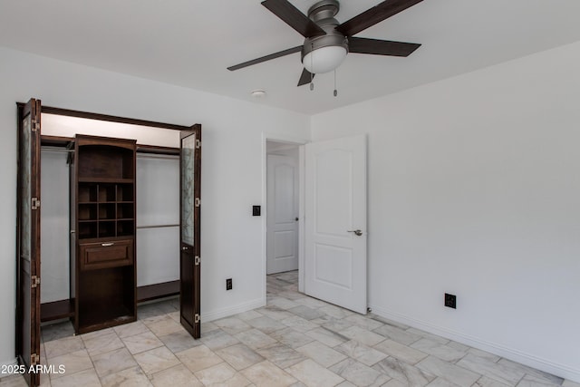 unfurnished bedroom featuring marble finish floor, baseboards, and a ceiling fan