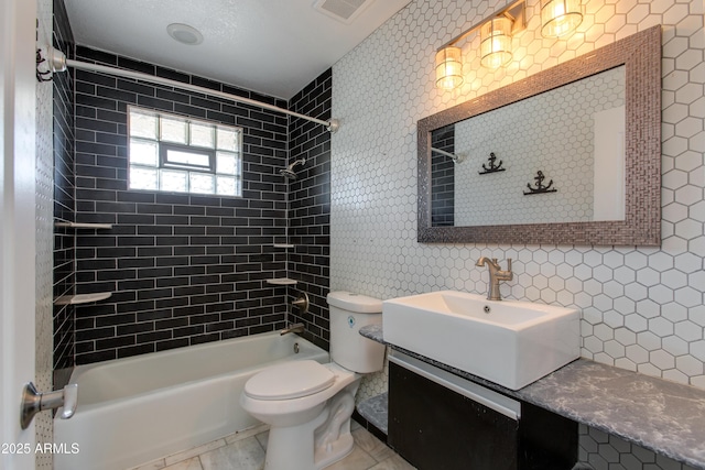 bathroom with vanity, washtub / shower combination, visible vents, tile patterned floors, and toilet