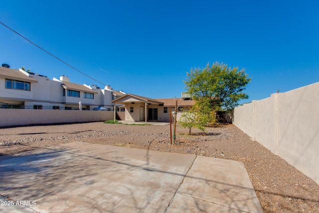 back of property with a residential view, a patio, and a fenced backyard