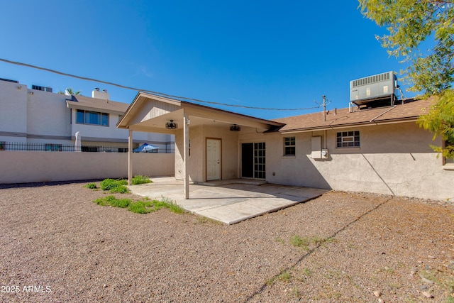 rear view of property with a patio, cooling unit, fence, and stucco siding