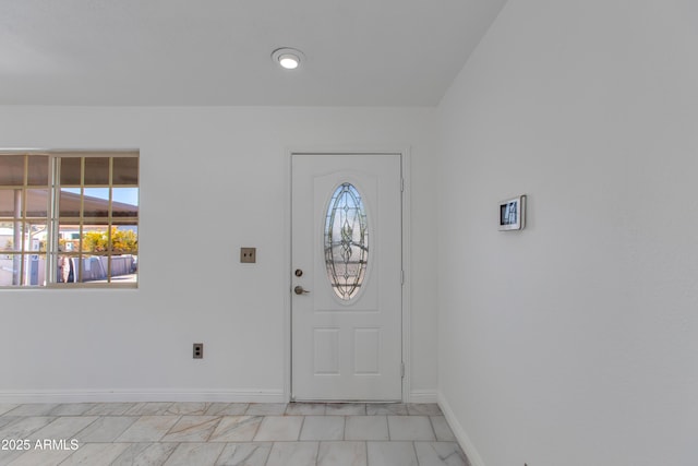 foyer entrance featuring plenty of natural light and baseboards