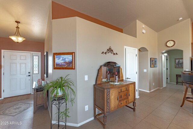 1398 W Sheep Wash Way, Benson, AZ 85602 - entrance foyer with arched walkways, baseboards, light tile patterned floors, and high vaulted ceiling
