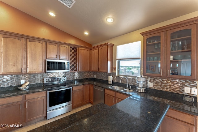 1398 W Sheep Wash Way, Benson, AZ 85602 - kitchen featuring stainless steel appliances, a sink, vaulted ceiling, decorative backsplash, and glass insert cabinets