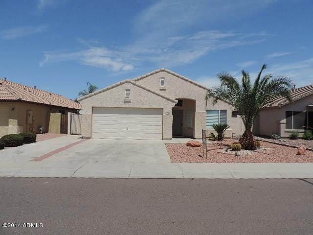 view of front facade with concrete driveway, an attached garage, and stucco siding