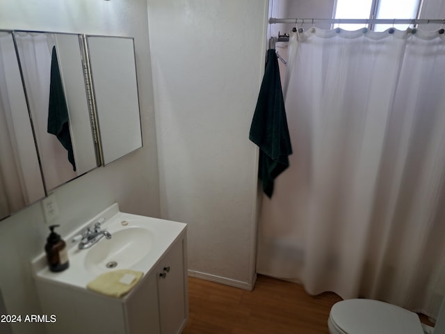 bathroom with toilet, vanity, and hardwood / wood-style flooring