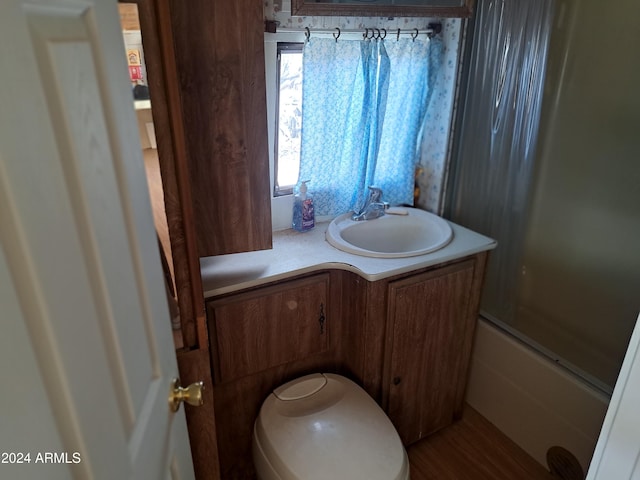 bathroom with vanity, enclosed tub / shower combo, and wood-type flooring