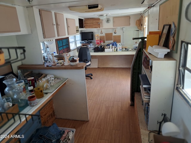 home office with a workshop area and light hardwood / wood-style flooring