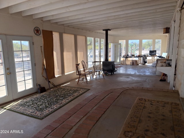 unfurnished sunroom with a wood stove and french doors