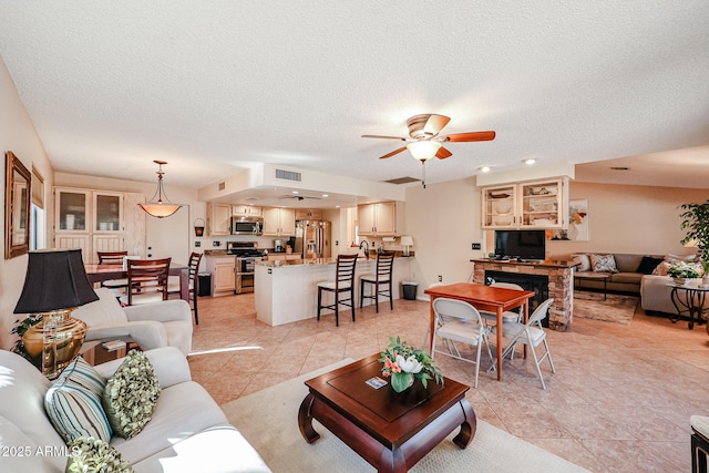 tiled living room featuring ceiling fan and a textured ceiling