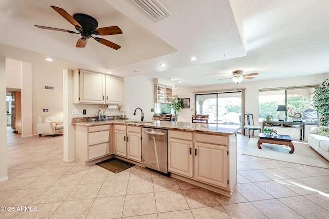 kitchen featuring stainless steel dishwasher, a raised ceiling, kitchen peninsula, a textured ceiling, and light tile patterned floors