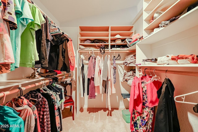 walk in closet with vaulted ceiling and carpet floors