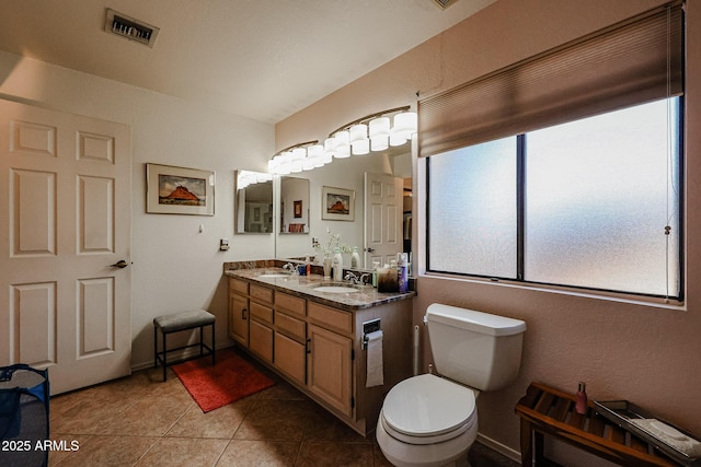 bathroom featuring toilet, vanity, and tile patterned flooring