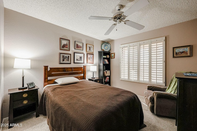 bedroom featuring a textured ceiling, ceiling fan, and light colored carpet