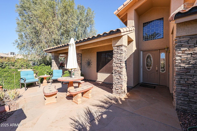 view of exterior entry featuring a patio area