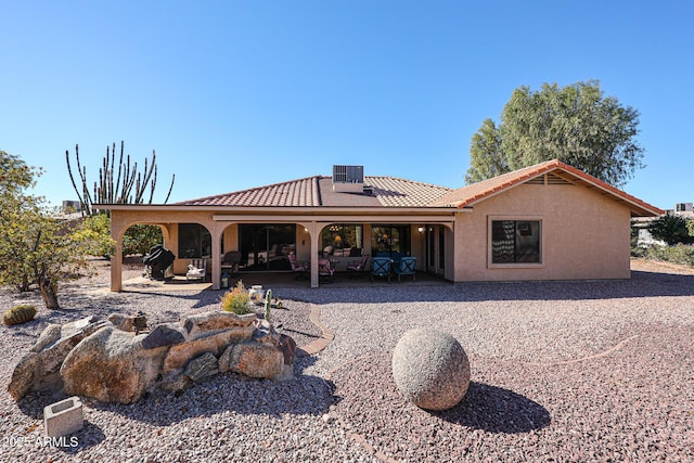 back of property with central AC unit and a patio area