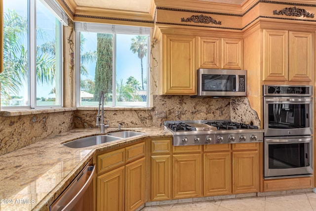 kitchen with a healthy amount of sunlight, appliances with stainless steel finishes, sink, and decorative backsplash