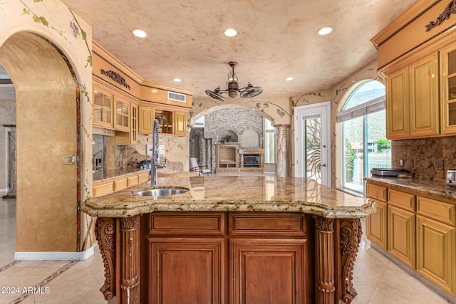 kitchen featuring decorative backsplash, decorative columns, a center island, and light tile patterned flooring