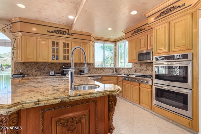 kitchen featuring light tile patterned flooring, tasteful backsplash, sink, stainless steel appliances, and light stone countertops