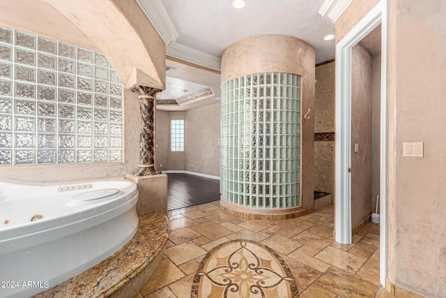 bathroom featuring decorative columns, crown molding, and a tub to relax in