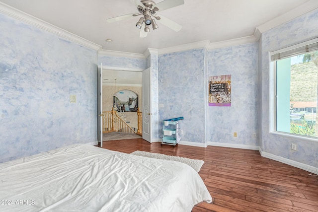 bedroom with multiple windows, crown molding, wood-type flooring, and ceiling fan