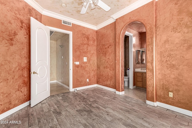 empty room featuring hardwood / wood-style floors, crown molding, and ceiling fan